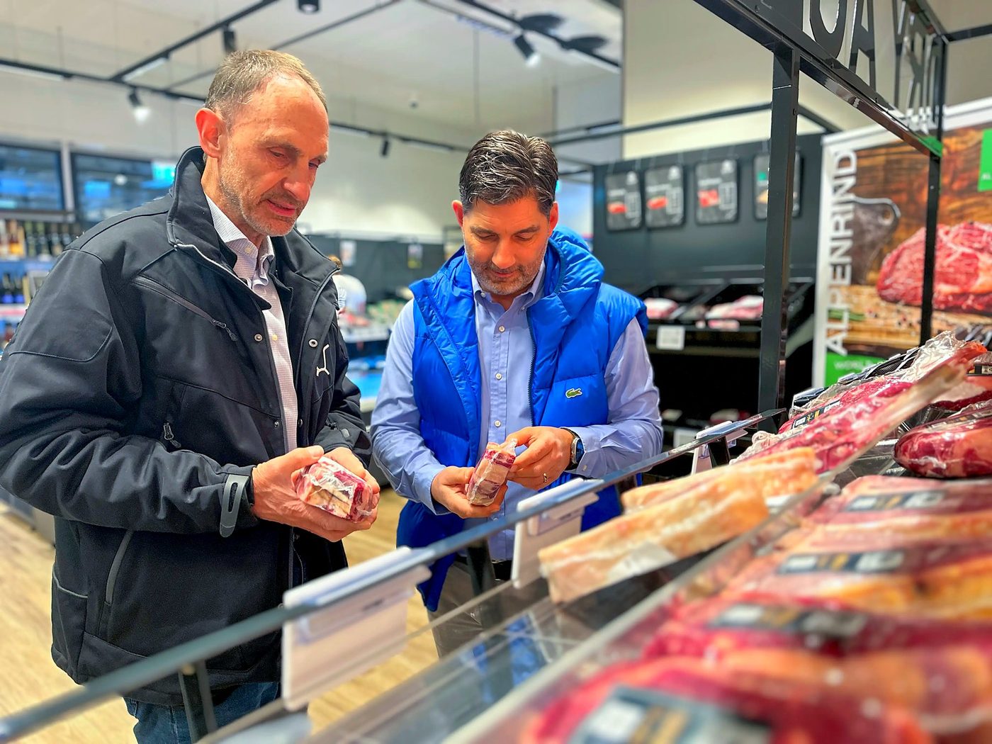 Zwei Kunden lassen sich an der Fleischtheke beraten