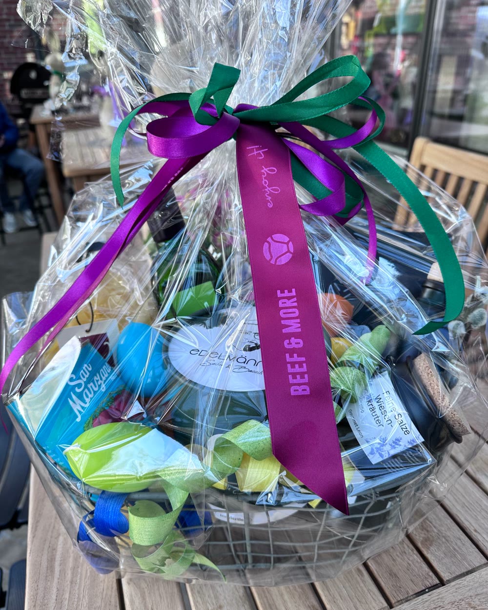 Fertig eingepackter Geschenkkorb mit Feinkost, Zellophan und der BEEF & MORE Schleife
