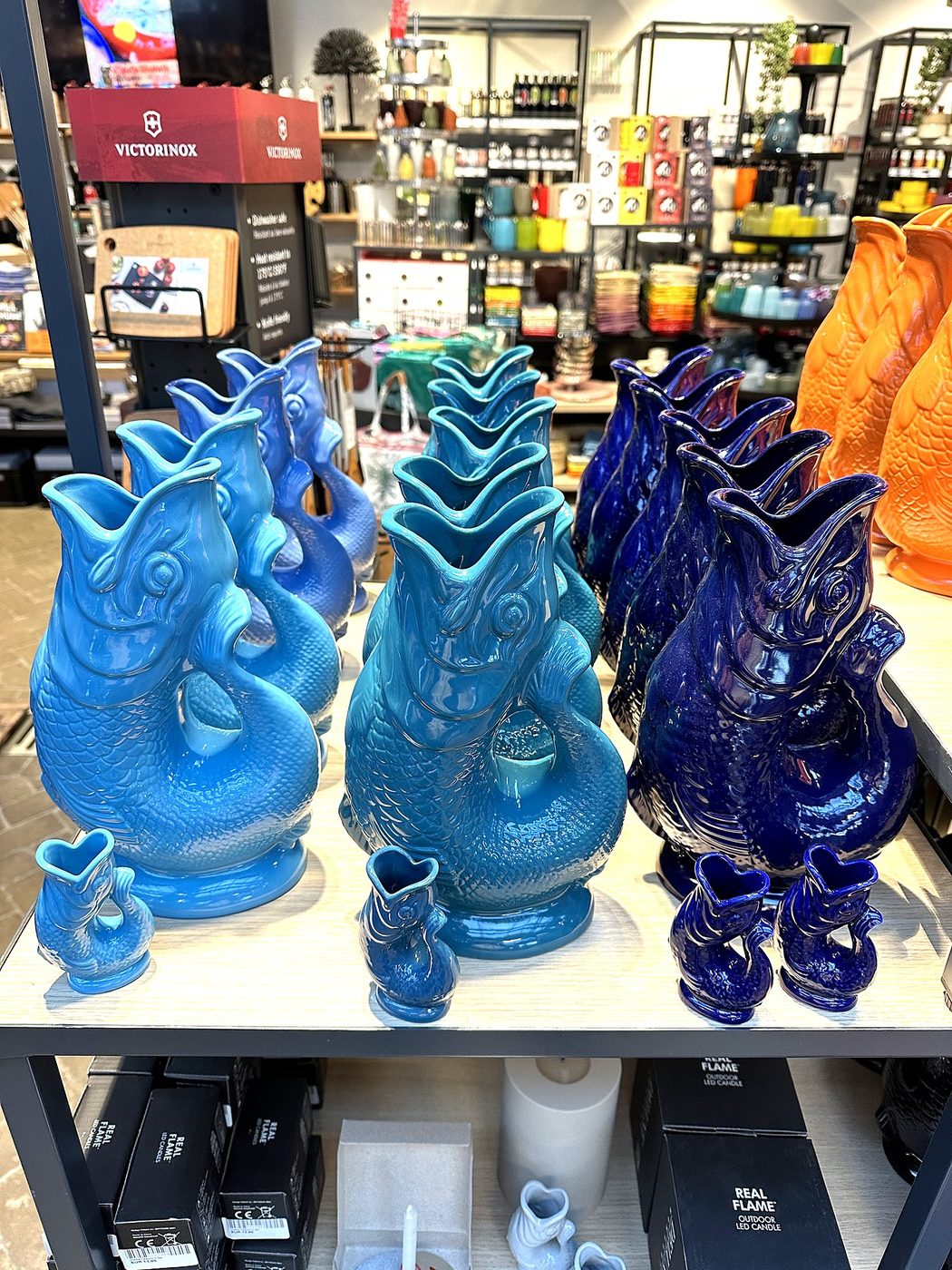 Gluckigluck-Krüge aus Glas in vielen Farben im Regal