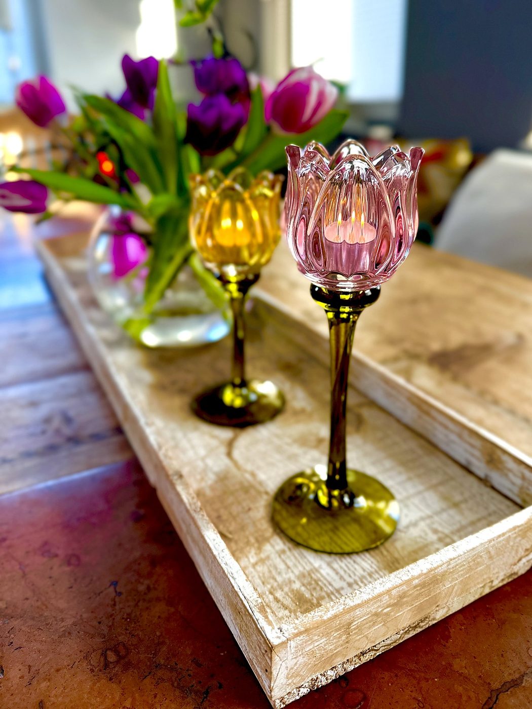 Tulpen und Kerzenhalter aus Glas auf einem Tablett